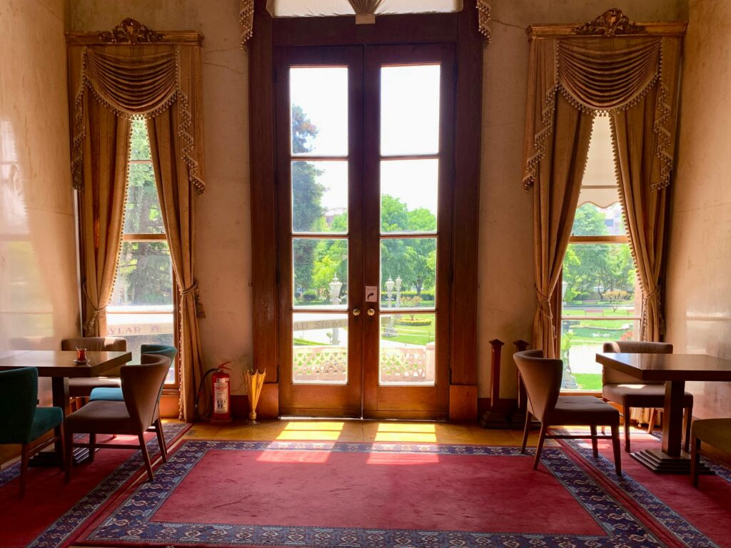 Luxurious interior with wooden French doors opening to a vibrant green garden.